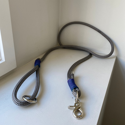 Grey rope dog leash with blue and purple accent on a white surface